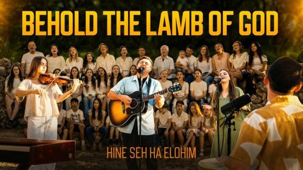 Guitarist and vocalist lead a worship band outdoors with a large choir behind, big orange text reading BEHOLD THE LAMB OF GOD at the top (album cover style).